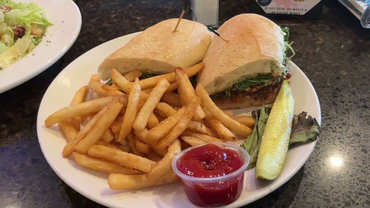 Real Pub 235 footage: a sandwich with fries, cooking on the grill, and a Pub 235 wine glass