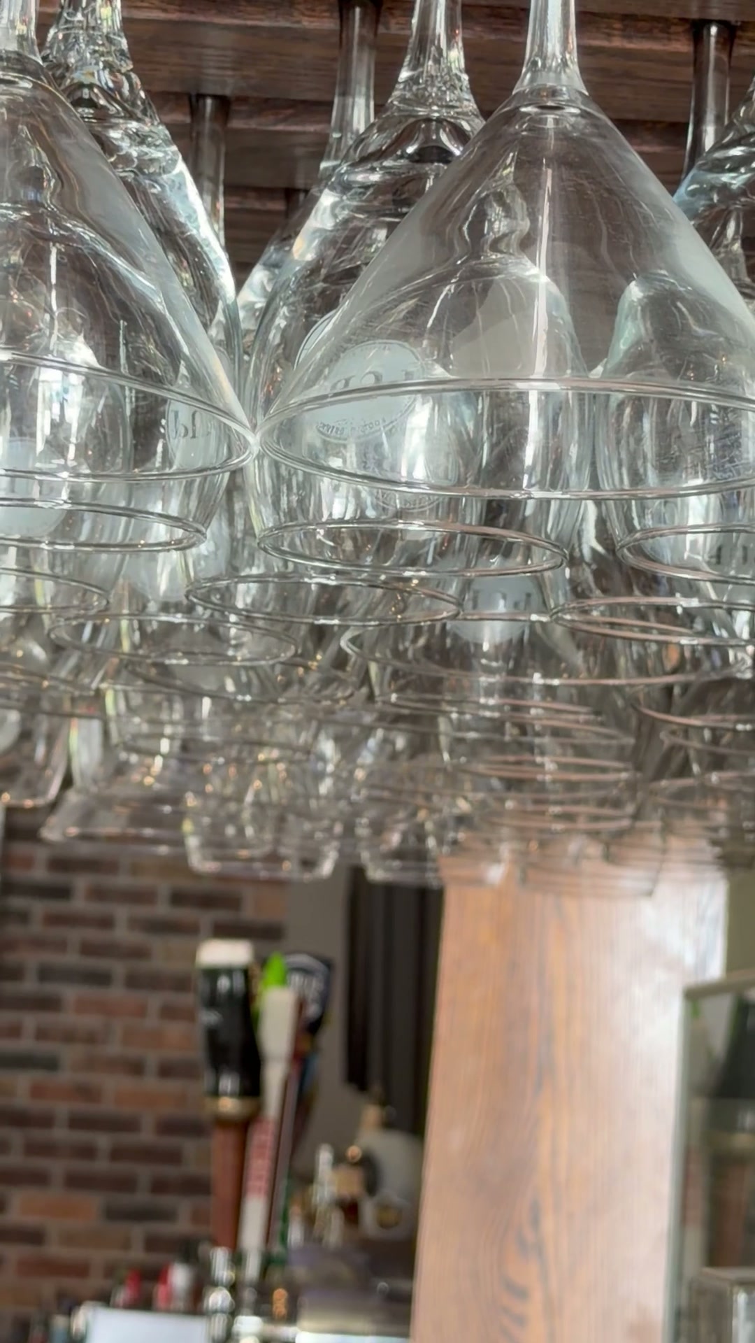 Hanging glassware and warm wood inside Pub 235
